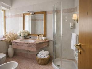 ein Badezimmer mit Waschbecken und Dusche in der Unterkunft Central Heritage Adults Only in Moena