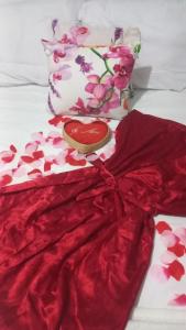 a red dress with a heart on a bed at Recanto Maristela in Grossos