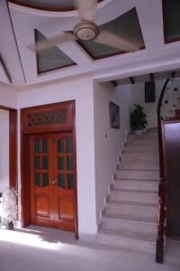 a house with a wooden door and stairs with a ceiling at Sehrai Royal Villa in Multan