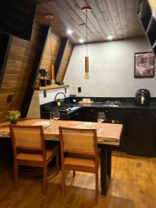 a kitchen with a wooden table and two chairs at Cabanas Girassol in Venda Nova do Imigrante +13 photos