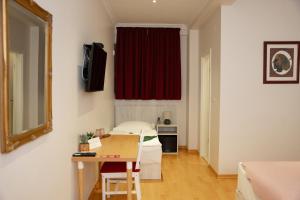 a room with a bed and a table and a red curtain at Boutique Hostel Livia in Metković