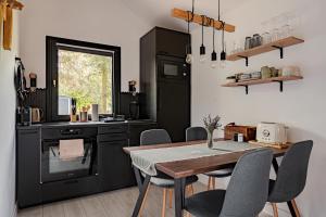 a kitchen with a table and chairs and a black refrigerator at Bodony Cottage in Bodony