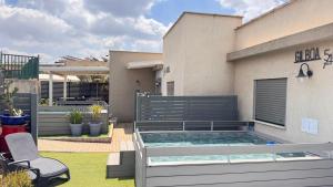 a backyard with a swimming pool and a house at 54You in Ahuzat Barak