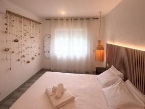 a bedroom with a white bed with towels on it at Apartmento 3037 in Quarteira