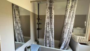 a bathroom with a mirror and a tub and a sink at L'Ombre du pommier in Paron