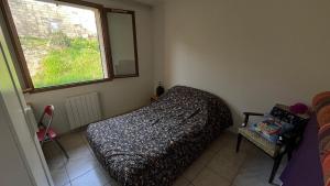 a bedroom with a bed and a window at L'Ombre du pommier in Paron