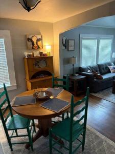 a living room with a wooden table and green chairs at The Gates House in Brady