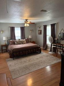 a bedroom with a bed with a rug and two windows at The Gates House in Brady