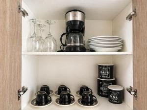 a cupboard with a coffee maker and dishes in it at Recanto Augusta in Londrina +26 photos