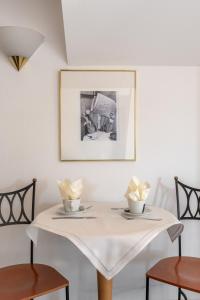 un tavolo bianco con due sedie e un quadro sul muro di Hotel Boulevard a Costanza Altre 28 foto