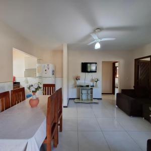 a living room with a dining table and a kitchen at Mestre Lord Apart Hotel 300m Praia Taperapuã by La Vem Férias in Porto Seguro