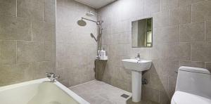 a bathroom with a tub and a sink and a toilet at 월호텔 in Pyeongtaek