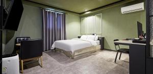 a bedroom with a bed and a desk with a computer at 월호텔 in Pyeongtaek