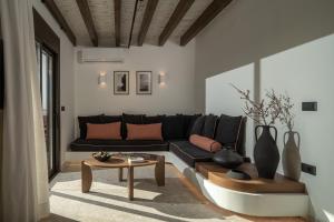 a living room with a black couch and a table at Abas Villas in Paránimfoi