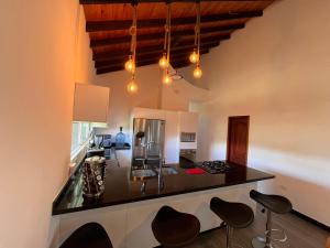 a kitchen with a counter with stools at Villa Edén Alto in La Tebaida