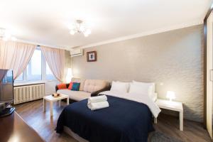 Lux Apartments - Yakimanka في موسكو: غرفة نوم بسرير كبير وأريكة