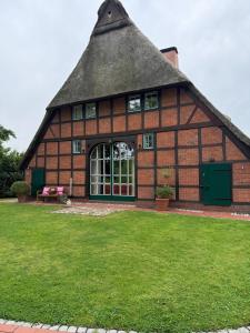 a large red brick building with a thatched roof at Reet-Denkmal am Elbstrand in Stade