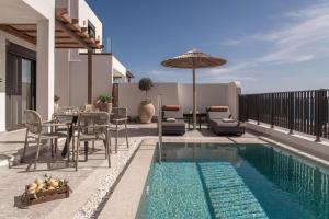 a patio with a table and an umbrella next to a pool at Abas Villas in Paránimfoi
