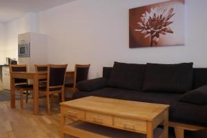 a living room with a couch and a table and chairs at Andrea 3 in Rauris