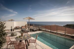 a patio with a table and chairs next to a swimming pool at Abas Villas in Paránimfoi +45 photos