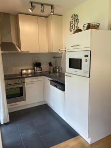 a kitchen with white cabinets and a white microwave at Christina 1 by SMR Apartments near Spa Gondola in Rauris