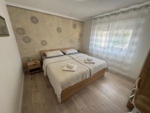 a bedroom with a bed with two towels on it at Apartments Gašparić in Barbat na Rabu