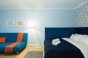 モスクワにあるLux Apartments - Lusinovskayaのベッドルーム(青いベッド1台、ソファ付)