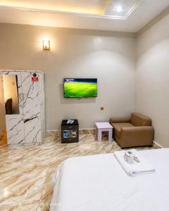 a hotel room with a bed and a couch and a tv at The Whale Inn Narayi rd Barnawa high cost in Kaduna