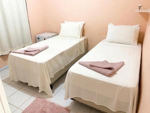 two beds in a room with towels on them at Casa do Anjo in Fernando de Noronha