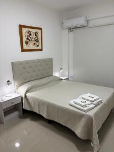 a bedroom with a bed with two towels on it at Benjamin 194 Suites in La Rioja +14 photos