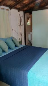 a blue bed with blue pillows in a room at Chalé Rústico Rota Bar 448 in Correia de Almeida +39 photos