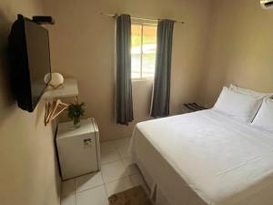 a bedroom with a white bed and a window at Casa do Anjo in Fernando de Noronha +24 photos