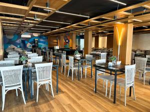 a dining room with tables and white chairs at Arrey Express Hotel - Teresina in Teresina