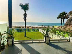 a balcony with a view of a beach and a palm tree at Luxurious Orchid Apartment in Bijilo