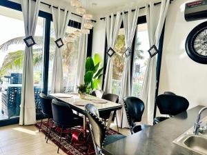 a dining room with a table and chairs and a clock at Luxurious Orchid Apartment in Bijilo