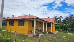 a yellow house with a red roof at Cabaña Santa Alicia in Villa de Leyva