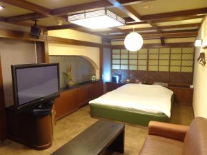 Schlafzimmer mit einem Bett und einem Flachbild-TV in der Unterkunft Hotel Piatt (Adult Only) in Nagoya