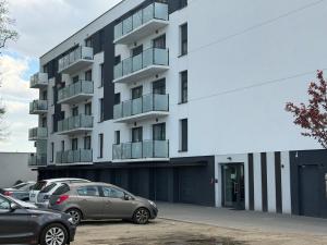 a building with cars parked in a parking lot at Apart Apartamenty Łowiecka 4A Free Parking in Leszno