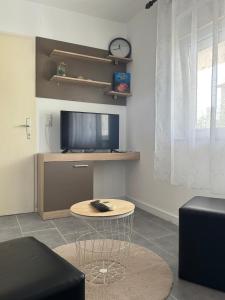 a living room with a table and a tv at Apartments Gašparić in Barbat na Rabu