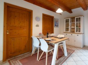 a kitchen with a wooden table and white chairs at Schwedenstern - Familienurlaub an der Ostsee in Kochendorf