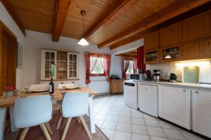a large kitchen with white appliances and wooden ceilings at Schwedenstern - Familienurlaub an der Ostsee in Kochendorf +15 photos