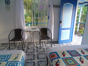 a room with two beds and a table and chairs at Vista Farallones Hostel in Jardin