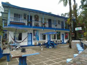 a blue and white building with a cat in front of it at Vista Farallones Hostel in Jardin