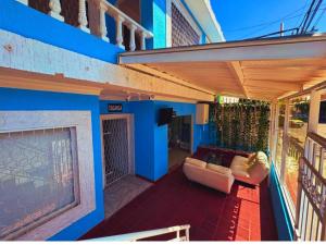 a patio with a couch and a tv on a house at Hotel Casa Manzanares in Santa Marta