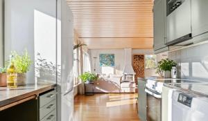 a kitchen with white cabinets and a wooden ceiling at Strömstad/Stromstad close to the sea in Strömstad