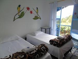 a bedroom with two beds and a window with a view at Vista Farallones Hostel in Jardin