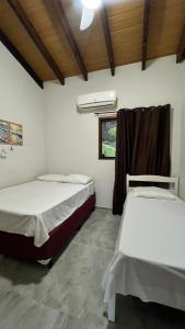 a room with two beds and a window at Sossego e Boa Vista in Ilhabela
