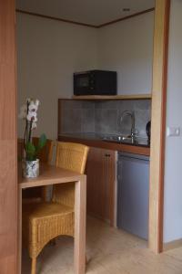 a kitchen with a table and chairs and a microwave at Maison Zélandaise in Koudekerke