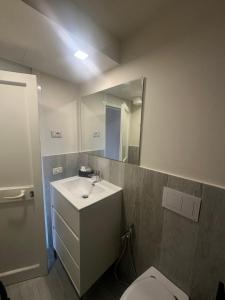 a bathroom with a sink and a toilet and a mirror at Il laghetto 19 in Capodimonte