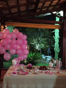 a table with a bunch of pink balloons on it at Chalé Rústico Rota Bar 448 in Correia de Almeida